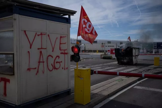 Graffiti reads “long live the CGT” at the blocked Marseille port entrance