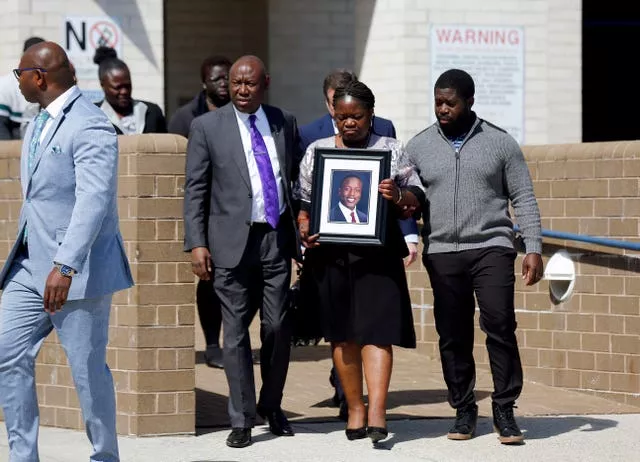 Irvo Otieno's mother Caroline Ouko holds a portrait of her son as she walks out of Dinwiddie Courthouse 