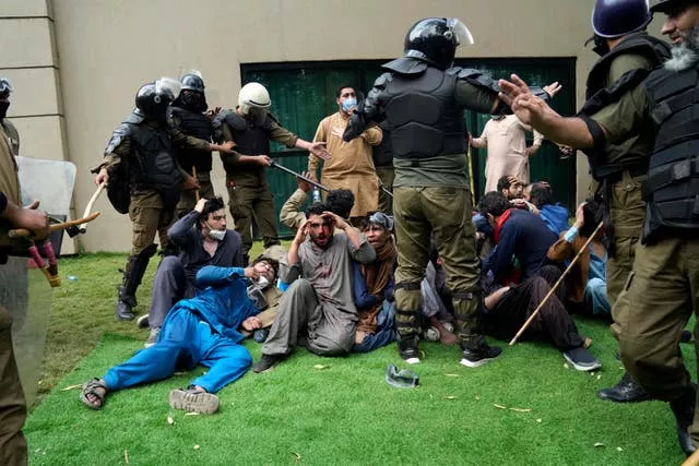 Police detain supporters of former prime minister Imran Khan during a search operation at his home in Lahore on March 18