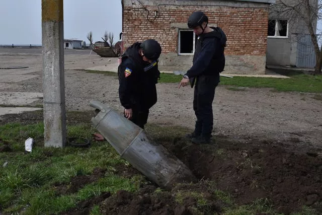 Emergency workers examine a FAB-500 unexploded Russian air bomb in the town of Preobrazhenka, Zaporizhzhia region, Ukraine