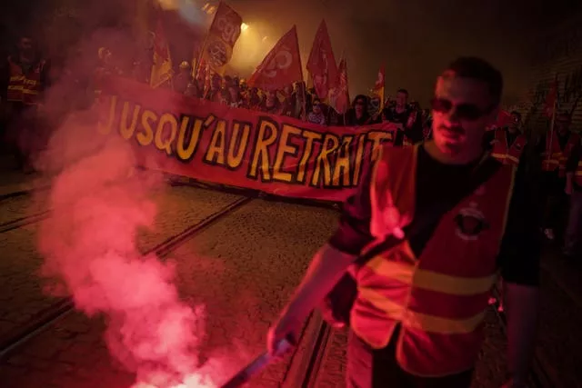 Railway workers hold a banner reading ‘Until withdrawal’ during a demonstration in Lyon, central France, on Wednesday