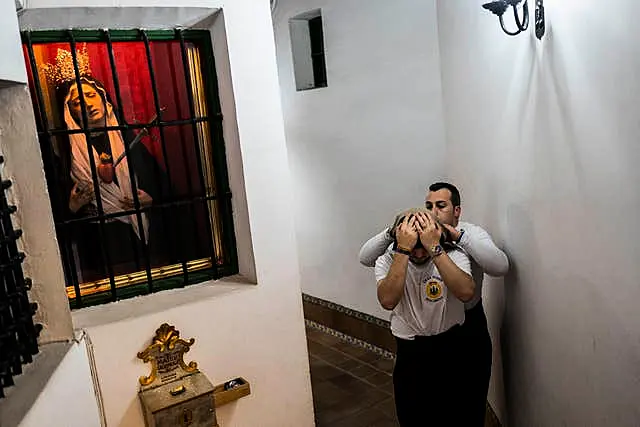 A porter of ‘Nuestro Padre Jesus del Gran Poder y la Esperanza Macarena’ brotherhood adjusts his ‘costal’ prior to practicing