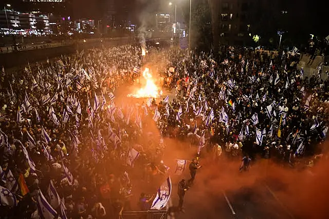 Israelis opposed to Prime Minister Benjamin Netanyahu’s judicial overhaul plan set up bonfires and block a motorway during a protest moments after the Israeli leader fired his defence minister, in Tel Aviv, Israel