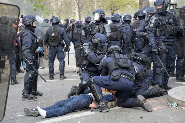 A man lies on the pavement after riot police officers charged during a demonstration in Paris 