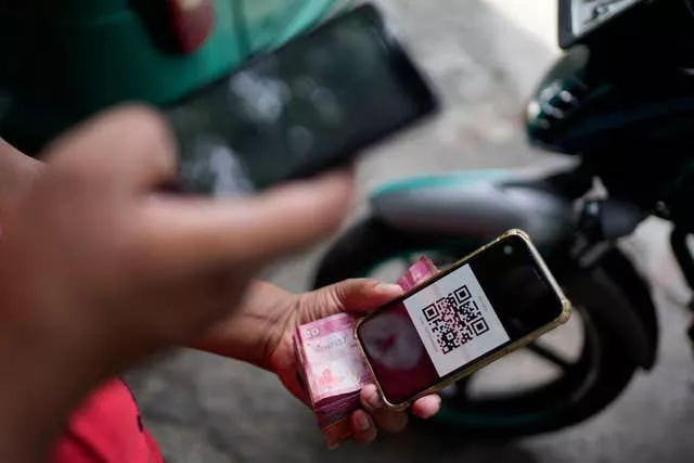 A worker scans a QR code at a petrol station in Colombo 