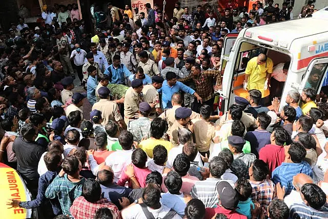 An accident victim is carried towards a waiting ambulance