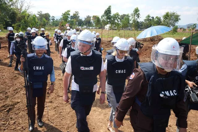 A Cambodia Mine Action Centre demining expert, right, leads Ukrainian deminers at a minefield in Preytotoeung village, Battambang province, Cambodia