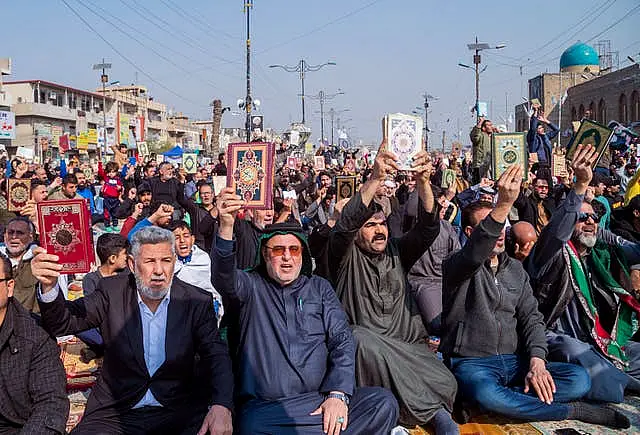 Followers of the Shiite cleric Muqtada al-Sadr raise the Koran, the Muslim holy book, in response to the burning of a copy of the Koran in Sweden, during open-air Friday prayers in Baghdad, Iraq