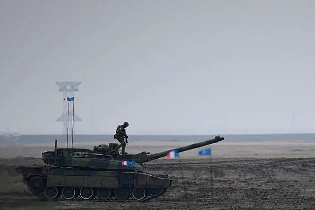 A French serviceman stands on a Leclerc main battle tank during the exercise