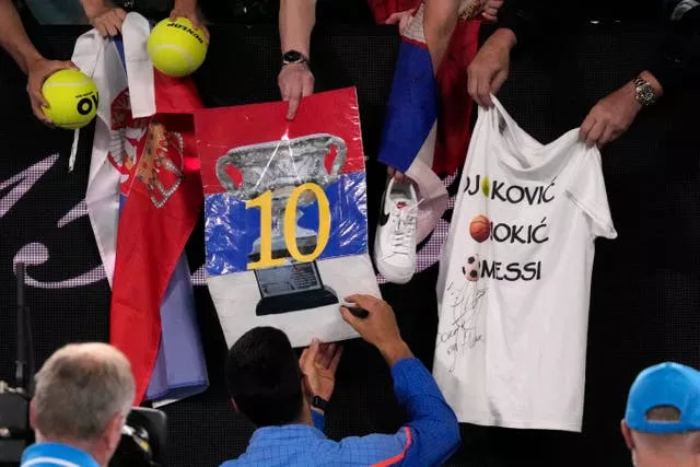 Novak Djokovic signs autographs for fans after his victory over Andrey Rublev