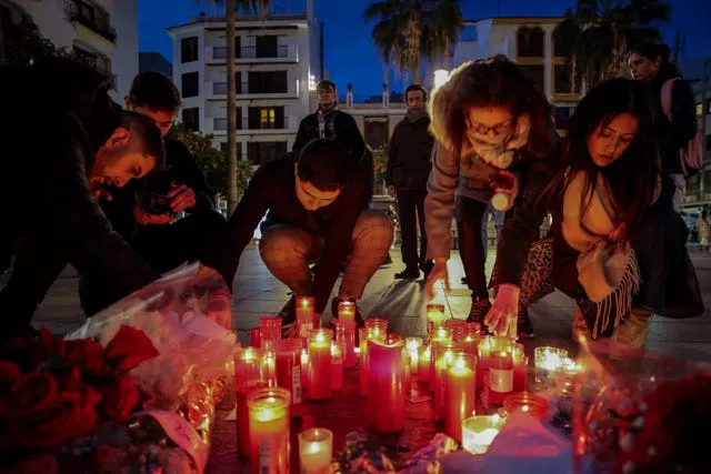 People light candles next to a memorial site for a church sacristan who was killed in Algeciras, southern Spain 