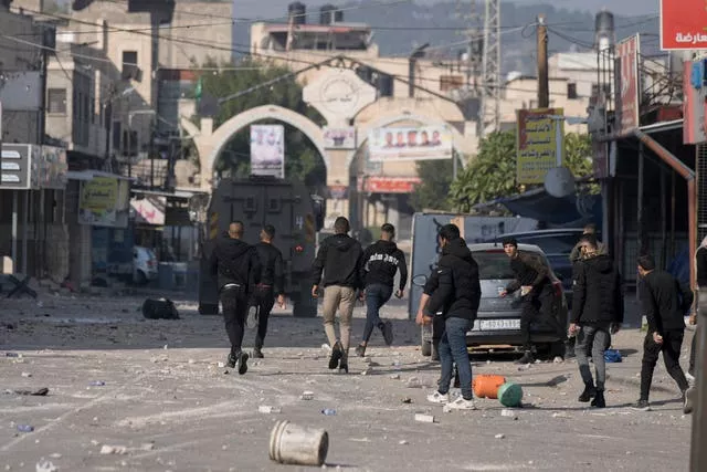 Palestinians clash with Israeli forces following an army raid in the West Bank city of Jenin