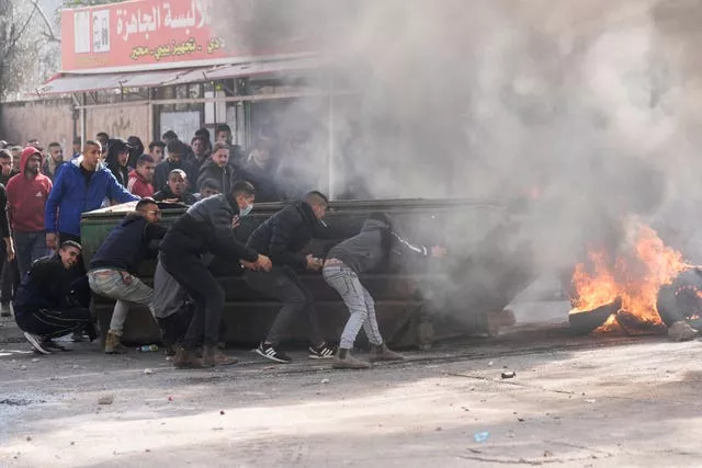 Palestinians clash with Israeli forces following an army raid in the West Bank city of Jenin