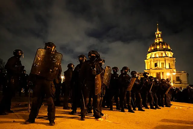 Riot police officers take position near the Invalides monument after a demonstration against plans to push back France’s retirement age in Paris