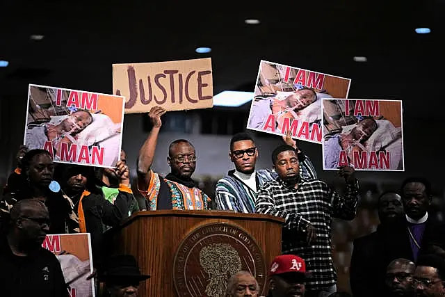 People hold signs during a news conference discussing the death of Tyre Nichols on Tuesday, Jan. 31, 2023, in Memphis, Tenn