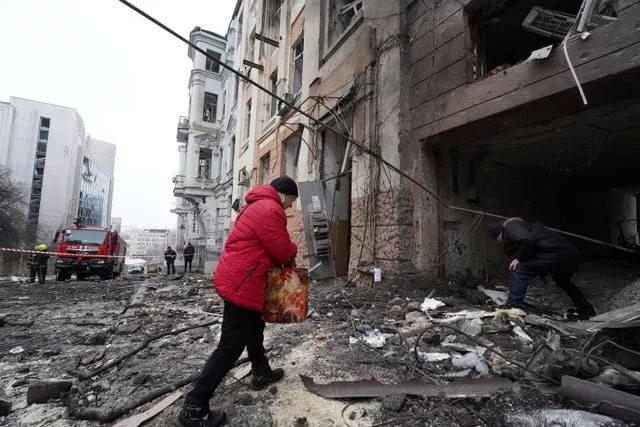 Man walks into rubble of house