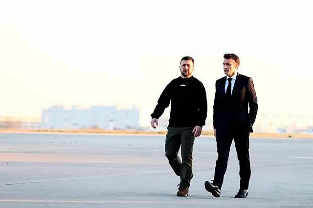 French President Emmanuel Macron, right, walks next to Ukraine’s President Volodymyr Zelensky before heading to Brussels