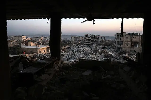 Collapsed buildings are seen through the windows of a damaged house following a devastating earthquake in the town of Jinderis, Aleppo province, Syria 