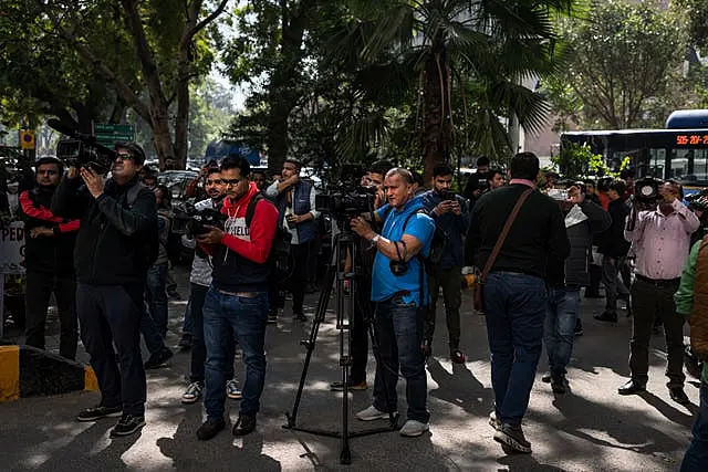 Media personnel report standing outside a building housing BBC office in New Delhi, India, on Tuesday