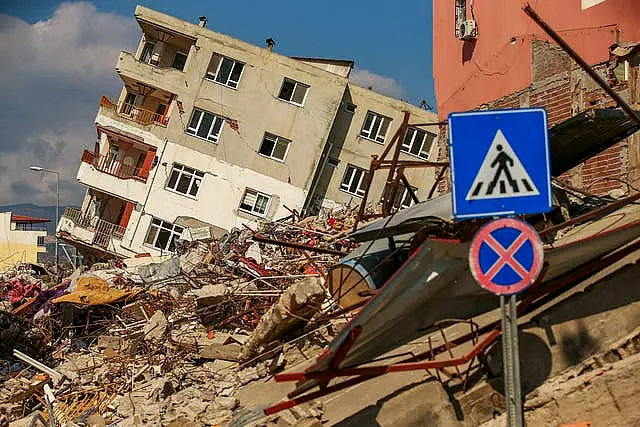 A destroyed building leans on a neighbouring house following the earthquake in Samandag, southern Turkey