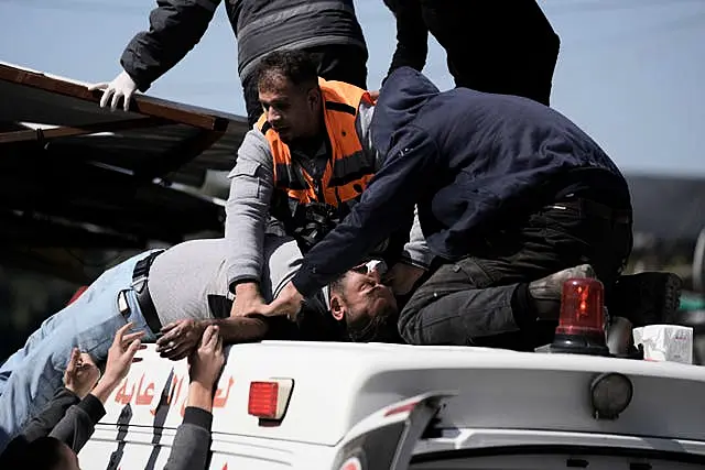 An injured Palestinian is lifted on to an ambulance