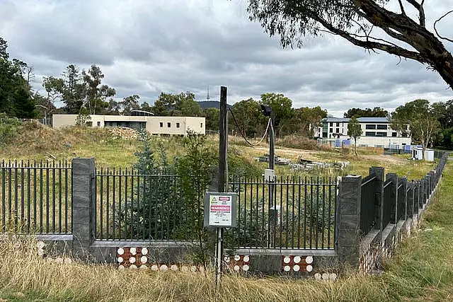 An unoccupied building, left, sits on the grounds of a proposed new Russian embassy, across from another building, right, that is part of the Chinese embassy near the Australian Parliament in Canberra, Feb. 28, 2023