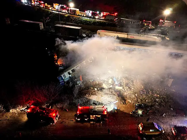 Smoke rises from trains as firefighters and rescuers operate after a collision near Larissa city, Greece, early on Wednesday, March 1, 2023