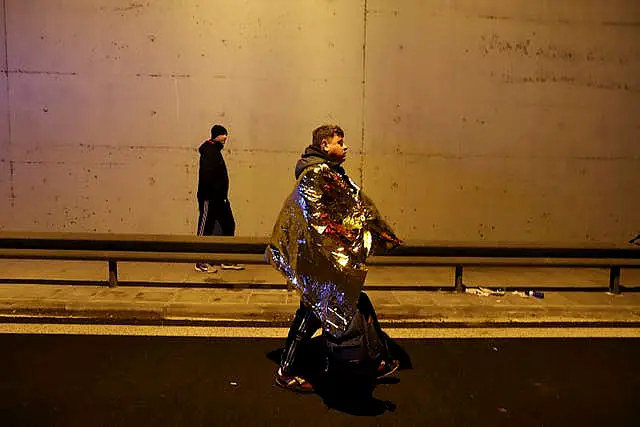 A passenger walks on a road after a train collision in Larissa city, Greece 