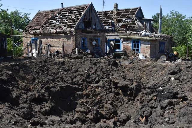 A crater is seen next to houses damaged by Russian shelling in Kushuhum, near Zaporizhia, Ukraine