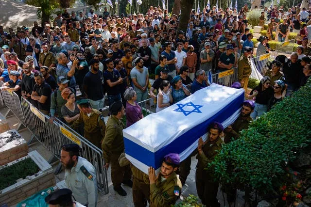 Israeli soldiers carry a flag-covered coffin
