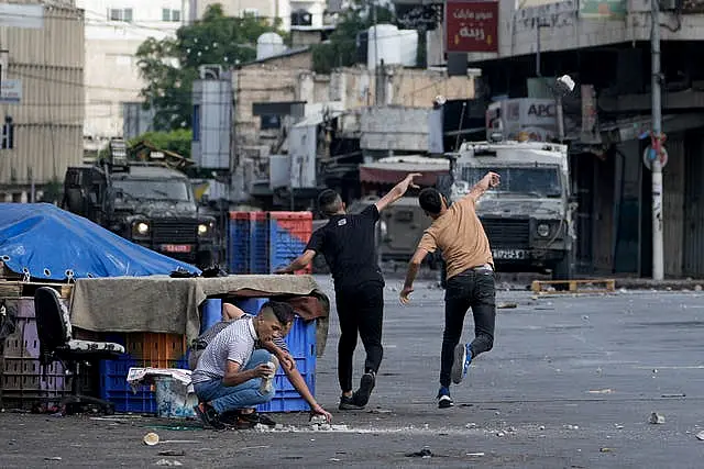 Palestinians clash with Israeli security forces during a military raid in the West Bank city of Nablus