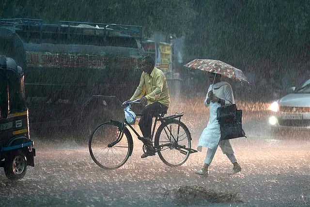 A woman walks in the rain in Jammu, India 