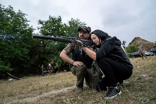 A woman is trained with a firearm