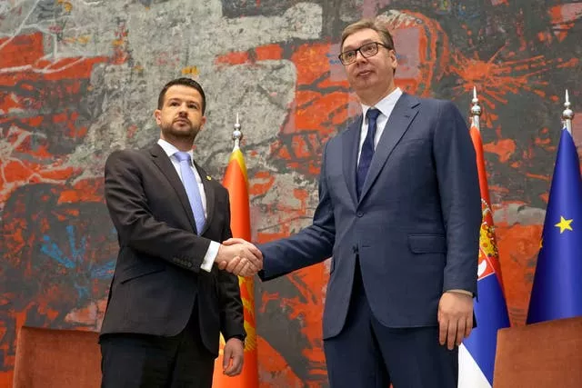 Montenegro’s President Jakov Milatovic with Serbian president Aleksandar Vucic shake hands