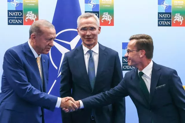 O presidente da Turquia, Recep Tayyip Erdogan, à esquerda, aperta a mão do primeiro-ministro da Suécia, Ulf Kristersson, à direita, enquanto o secretário-geral da Otan, Jens Stoltenberg, observa