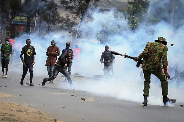 Police and protesters surrounded by smoke