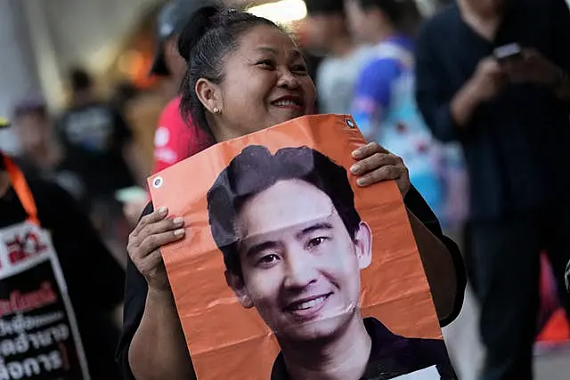 A Move Forward Party supporter holding a poster of leader Pita Limjaroenrat 