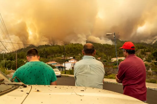Local residents look at a burning forest fire near Puntagorda on the Canary Island of La Palma