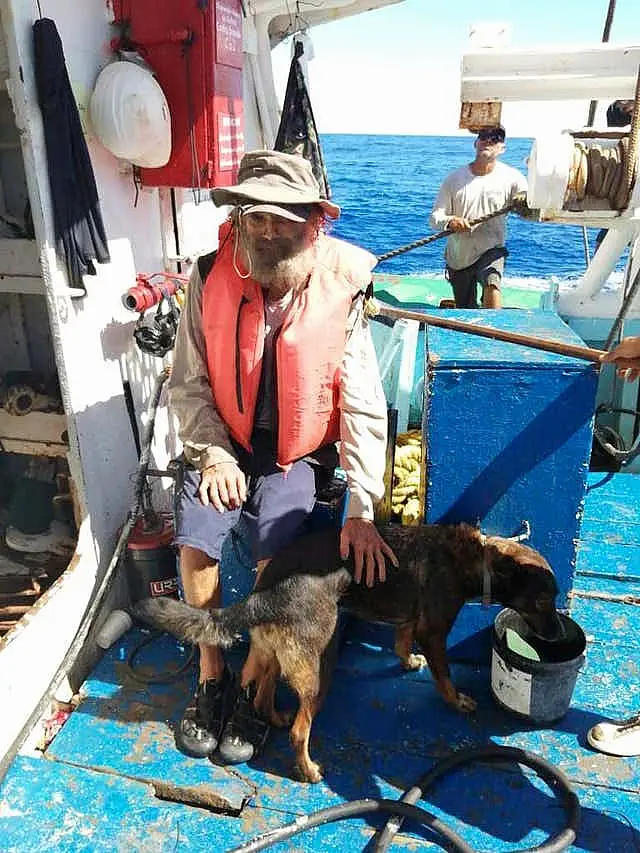 Tim Shaddock sits with his dog Bella after being rescued