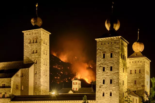 Smoke and flames are seen from a burning forest behind the Stockalper palace above the communes of Bitsch and Ried-Moerel in Bitsch, Switzerland