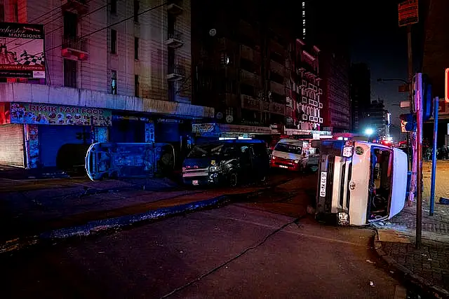 Minibus taxis lie on their side at the scene of the suspected gas explosion