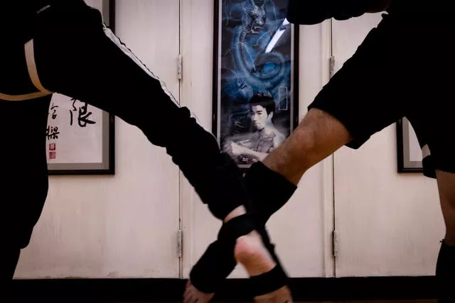 Practitioners train in front of a photograph of Bruce Lee during a Jeet Kune Do class in Hong Kong