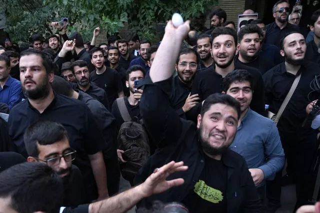 A demonstrator throws an egg at the Swedish Embassy in Tehran during a protest over the desecration of the Koran in Sweden