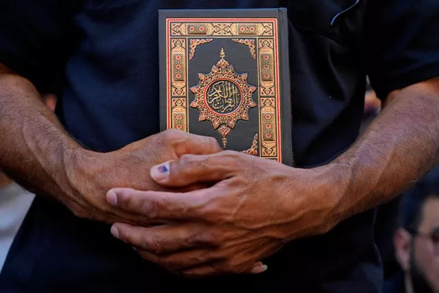 A protester holds a Koran