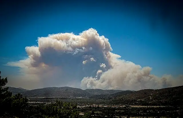 A cloud of smoke from a forest fire rises over the island of Rhodes