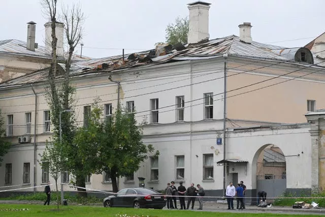 Investigators examine an area next to a damaged building after a reported drone attack in Moscow