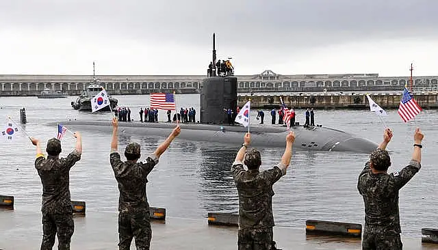 South Korean navy sailors wave as the USS nuclear-powered submarine USS Annapolis arrives at a naval base on Jeju Island