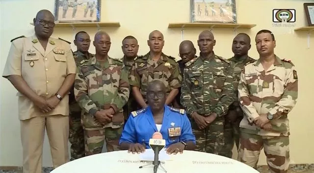 Colonel Major Amadou Abdramane, front centre, makes a statement late on Wednesday in Niamey as a delegation of military officers appeared on state TV to read out a series of communiques announcing their coup d’etat