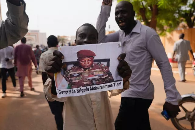 Nigeriens participate in a march called by supporters of coup leader Gen. Abdourahmane Tchiani, pictured
