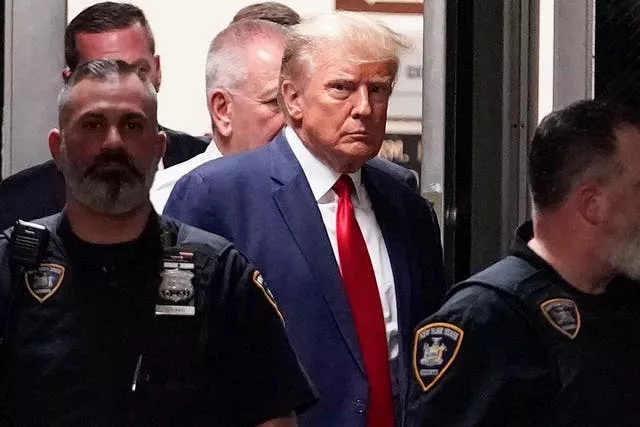 Donald Trump sendo escoltado para um tribunal em Nova York em 4 de abril